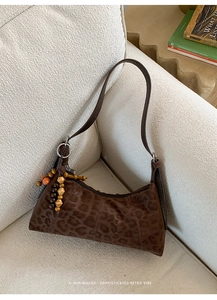 Detail der Vintage-Hobo-Tasche mit Leopardenmuster und Perlenanhänger auf Wildlederoptik