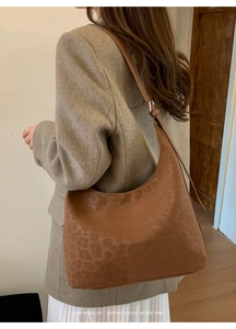 Close-up of leopard print hobo bag texture and adjustable leather strap detail