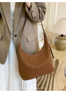 Close-up of vintage leopard print hobo shoulder bag styled in a minimalist interior setting