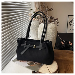 Dettaglio borsa tote in pelle scamosciata nera con fibbia dorata e spalline sottili