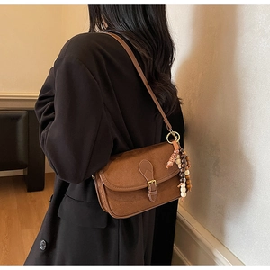 Detail of vintage brown frosted leather bag with decorative beaded strap accessory