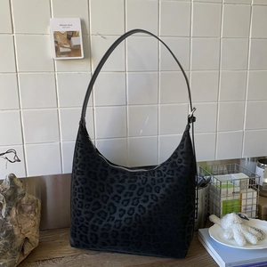 Detailed view of the leopard print pattern and suede texture of the black hobo shoulder bag