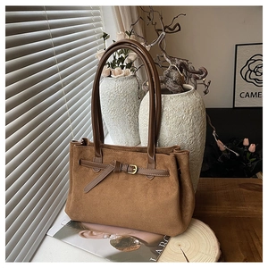 Dettaglio della borsa tote in pelle scamosciata color caramello con fibbia in metallo oro