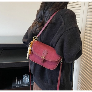 Détail du sac besace bordeaux givré avec perles vintage et boucle dorée élégante