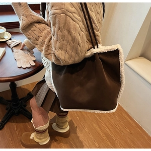 Braune Shopper-Tasche aus Lammwolle kombiniert mit Strickpullover und Faltenrock