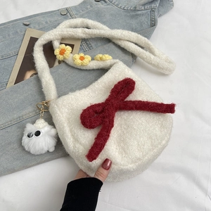 Sac bandoulière en peluche blanche avec nœud rouge et fleurs sur une veste en jean