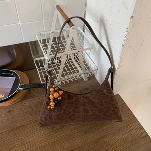 Detailansicht der braunen Schultertasche mit Leopardenmuster und Holzperlenanhänger