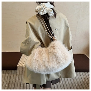 Detailaufnahme der flauschigen beigen Plüschtasche mit Lederriemen an einem Model