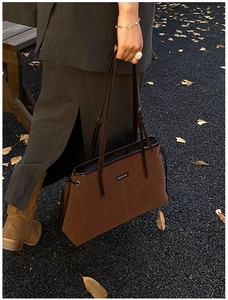 Detailaufnahme der dunkelbraunen Tote Bag mit Leopardenmuster, Metalllogo und Lederriemen