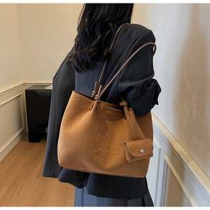 Detail of camel brown faux suede tote bag featuring unique knotted shoulder strap design