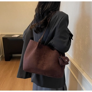 Detail view of large dark brown suede tote bag with matching small coin purse attachment