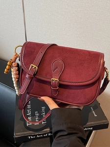 Sac bandoulière vintage bordeaux en daim givré avec détails dorés et breloque