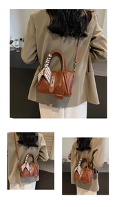 Detail of brown PU leather bucket bag with checkered scarf handle and hanging tag