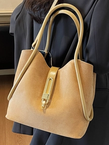 Large khaki suede tote bag with golden U-shaped buckle shown on model shoulder
