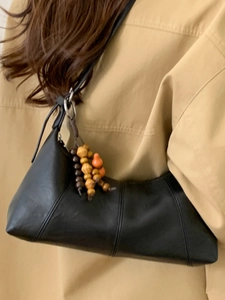 Minimalistische schwarze Unterarmtasche aus mattem Leder mit Holzperlenanhänger und Anhänger