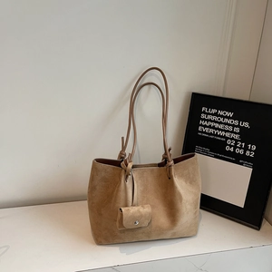 Detail of khaki suede tote bag with matching mini coin purse in a lifestyle scene