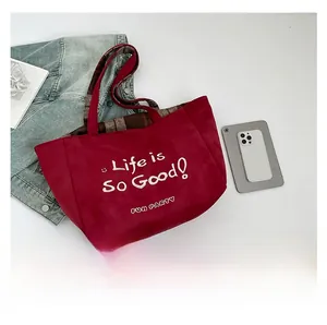Detail der roten Wildleder-Tasche mit Life is So Good Print und Karo-Tragegriffen