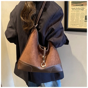 Detailed close-up of brown suede tote bag featuring white contrast stitching and metal ring