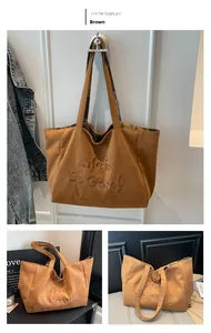 Nahaufnahme braune Wildleder-Tragetasche mit Stickerei und kariertem Vintage-Futter