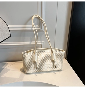 Détail du sac cabas plissé beige avec bandoulière à nœud élégante et aspect texturé