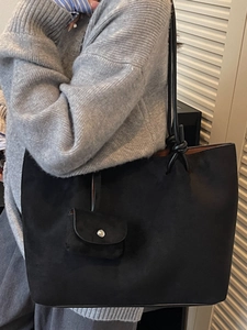 Minimalist black matte leather tote bag with functional mini pouch and knotted handle detail