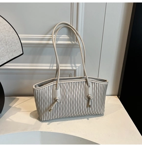 Détail du sac cabas plissé crème avec texture en cuir souple et finitions en métal doré