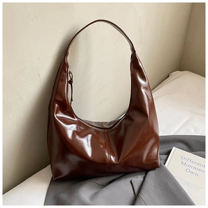 Detail of glossy deep brown hobo bag showing its polished surface and sleek zipper closure