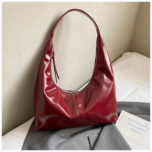 Macro detail of high-shine burgundy hobo bag showing its vintage glossy texture and stitching