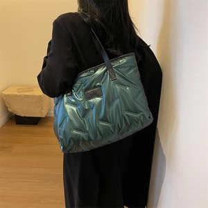 Metallic green quilted down tote bag with a high-gloss finish and black logo patch