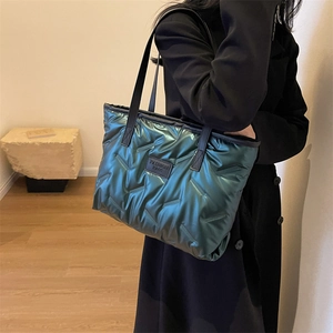 Deep green metallic quilted puffer tote bag with long black handles and fashion logo
