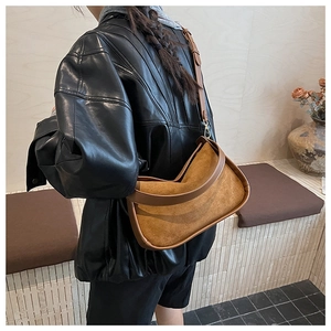 Close-up of vintage brown faux suede bowling bag with smooth leather trim details