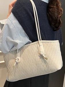 Sac cabas matelassé chic de couleur crème avec doubles fines bretelles et nœuds en métal