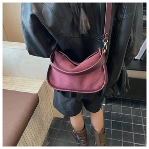 Detail view of burgundy faux suede hobo bag with adjustable strap and matte finish