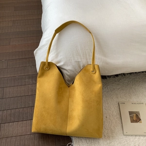 Détail du sac cabas minimaliste en daim jaune gingembre avec ouverture en V profond