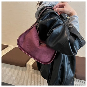 Detail of burgundy suede bowling bag texture and smooth leather trim for women