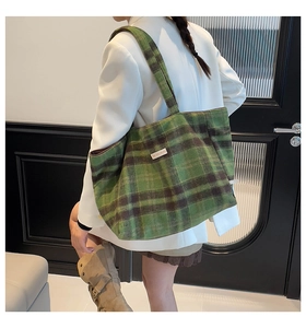 Detail der grün-braun karierten Woll-Tote-Bag kombiniert mit weißem Blazer und Rock