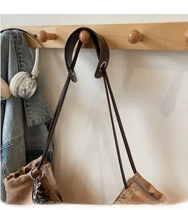 Detail of a vintage brown leather tote bag with drawstring folds and long shoulder straps