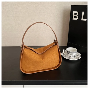 Close-up of caramel suede hobo bag with smooth leather trim and metal hardware accents
