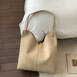 Détail du grand sac cabas en daim beige clair avec ouverture en V et bretelles sobres