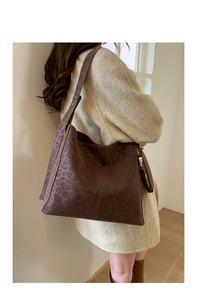 Deep brown leopard print matte tote bag with matching coin purse on a model shoulder