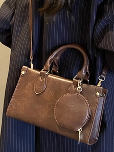 Minimalist brown crossbody square bag with small round coin pouch and gold hardware