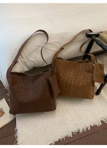 Detail of matte leopard print tote bag set with matching coin purse on white rug