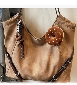 Detail view of retro brown large tote bag with adjustable strap and donut charms