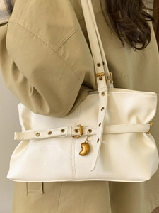 Borsa tote beige minimalista con occhielli metallici e ciondolo dorato decorativo donna