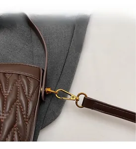 Dettaglio borsa in pelle marrone trapuntata con finiture in metallo dorato vintage