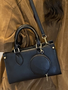 Chic black faux leather crossbody bag with round coin purse and gold hardware on model