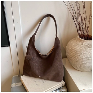 Detail of dark brown suede Hobo bag with logo and drawstring tassels on a studio set