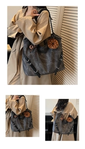 Detail of grey washed canvas tote bag with black leather straps and metal rings