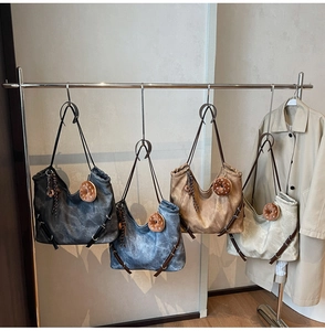 Four colors of vintage large tote bags with donut charms displayed on a metal rack