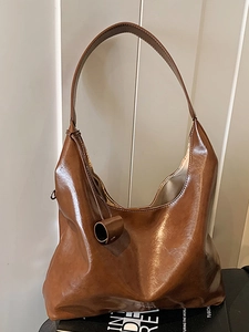 Brown high-capacity glossy leather tote bag with wide shoulder strap in hobo style